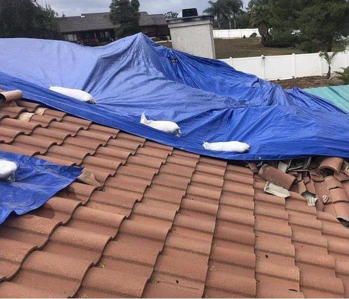 SERVPRO of Santee Lakeside technicians lay a tarp to prevent water damage in a fire burn damaged roof in San Diego, CA