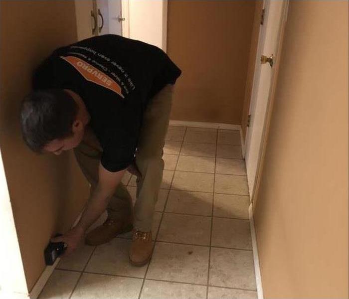 SERVPRO technician uses moisture meter to determine where water damage is most severe to determine source of water damage